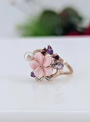 bague cocktail en or rose ornée d'une fleur en corail teinté rose entourée d'une perle de culture, des pierres de couleur et 2 pet