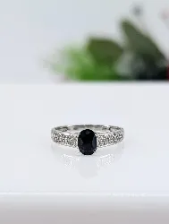 bague en or blanc centrée d'un saphir bleu foncé dans une pavage de petits diamants or 375 millième (9 ct) 1,54g