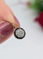 pendentif rond centré d'une pavage de diamants taille ancienne entourés de saphirs taille trapèze or 750 millième (18 ct) 1,27g