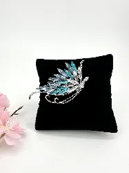 broche papillon en métal argenté ornée des strass blancs et bleus dégradés