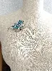 broche papillon en métal argenté ornée des strass blancs et bleus dégradés