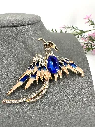 broche phénix en métal doré et émaillé ornée des strass bleus et blancs