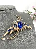 broche phénix en métal doré et émaillé ornée des strass bleus et blancs