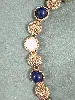 collier signé monet doré avec pierre bleu et blanche