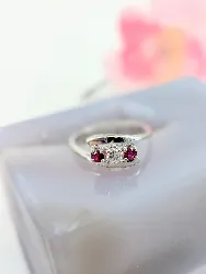 bague or blanc centrée d'un diamant d'environ 0,12ct epaulé de deux rubis or 750 millième (18 ct) 2,37g