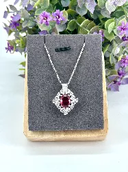 collier avec pendentif centré d'une pierre rose entourée d'oxydes