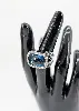 bague cocktail centrée d'une topaze facetée serti clos entourée de petits diamants et de saphirs sur le panier or 750 millième (18