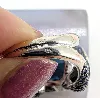 bague cocktail centrée d'une topaze facetée serti clos entourée de petits diamants et de saphirs sur le panier or 750 millième (18