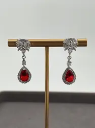 boucles d'oreilles pendantes chacune centrée d'une pierre rouge entouré d'oxydes