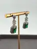 boucles d'oreilles pendantes chacune centrée d'une pierre verte entouré d'oxydes