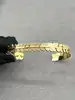 bracelet jonc ouvert motif feuille en métal doré