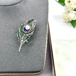 broche motif plume pavée d'oxydes en acier