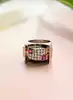 bague tank avec une pavage d'oxydes et pierres rouges surmontée sur une face creuse en or rose 18k argent 800 millième (19 ct) 11,