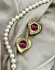 boucles d'oreilles clip yves saint laurent motif coeur doré et pierre rose