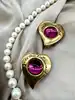 boucles d'oreilles clip yves saint laurent motif coeur doré et pierre rose