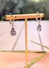 boucles d'oreilles dormeuses en or blanc chacune sertie d'une tanzanite forme poire surmontée d'un diamant taille brillant or 750 