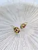 boucles d'oreilles dormeuses motifs fleurs vidées chacune sertie d'un rubis or 750 millième (18 ct) 1,15g