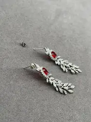 boucles d'oreilles pendantes chacune avec d'une pierre rouge
