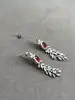 boucles d'oreilles pendantes chacune avec d'une pierre rouge