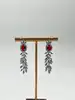boucles d'oreilles pendantes chacune avec d'une pierre rouge