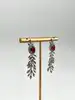boucles d'oreilles pendantes chacune avec d'une pierre rouge