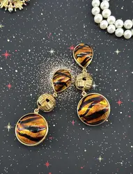 boucles d'oreilles pendantes clip vintage yves saint laurent en métal doré et pierre marron avec motif