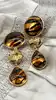 boucles d'oreilles pendantes clip vintage yves saint laurent en métal doré et pierre marron avec motif