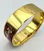 bracelet jonc hermès en émail, orné d'un motif de chevaux rouges, avec finition plaquée or