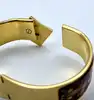 bracelet jonc hermès en émail, orné d'un motif de chevaux rouges, avec finition plaquée or