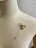 broche épingle salvatore ferragamo noeud en métal doré