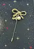 broche épingle salvatore ferragamo noeud en métal doré
