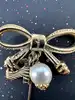 broche épingle salvatore ferragamo noeud en métal doré