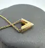 collier louis vuitton essential v en laiton à finition dorée
