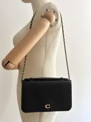 sac pochette coach en cuir grainé noir, chîne dorée détachable