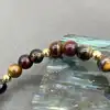 bracelet élastiqué boules en pierre oeil de tigre, oeil de taureau et oeil de faucon d6,5mm et métal doré d4mm