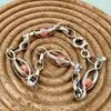 bracelet en argent orné de perles roses logées dans des maillons ajourés argent autre 6,63g