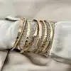 bracelet semainier 7 joncs ouverts en acier doré