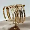 bracelet semainier 7 joncs ouverts en acier doré
