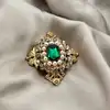 broche ornée d'oxydes et perles synthétiques en métal doré