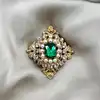 broche ornée d'oxydes et perles synthétiques en métal doré
