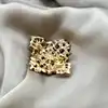 broche ornée d'oxydes et perles synthétiques en métal doré