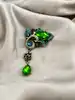 broche pavée d'oxydes verts et bleus